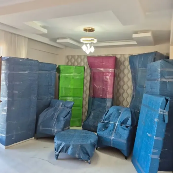 Mavi taşıma battaniyesiyle paketlenmiş koltuk takımı ve dolaplar